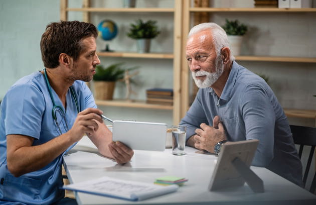 Male Doctor Using Touchpad Explaining Medical Test Results His Senior Patient Medical Appointment