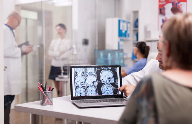 Senior Woman Hospital Office Looking Brain Ct Scan While Discussing With Doctor About Diagnosis Sick Young Woman Elderly Medic With Grey Hair Clinic Corridor