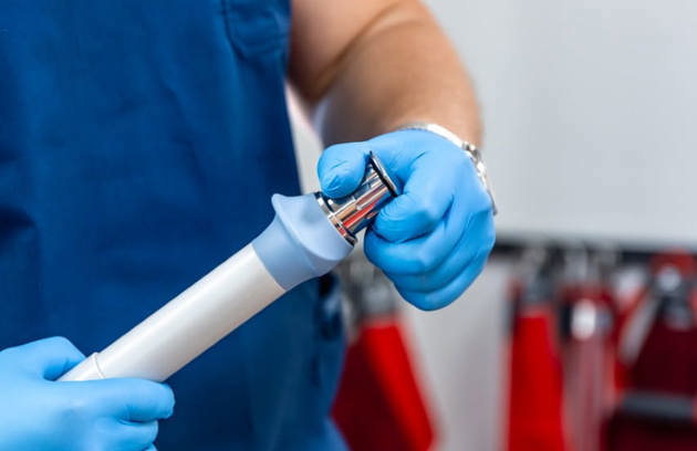 A healthcare professional preparing an endoscope for a diagnostic procedure during Endoscopy in Sharjah.