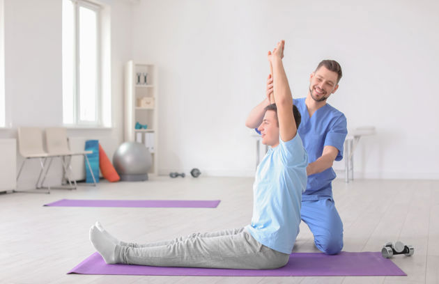 A patient performing guided stretching exercises during a Physiotherapy in Sharjah rehabilitation session.
