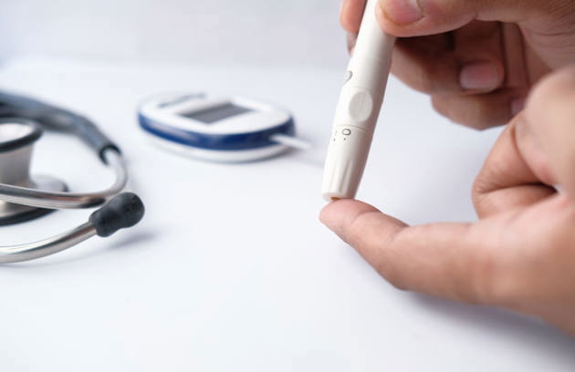 An Endocrinologist in Sharjah performing a blood glucose test during a diabetes consultation.
