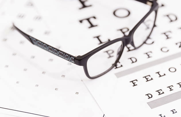 An eye chart and eyeglasses used during a vision examination by an Eye Specialist in Sharjah.