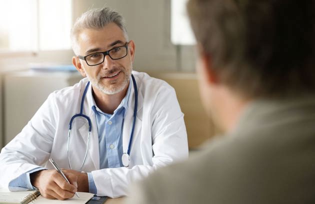 A psychiatrist in Sharjah discussing mental health concerns with a patient during a private consultation.