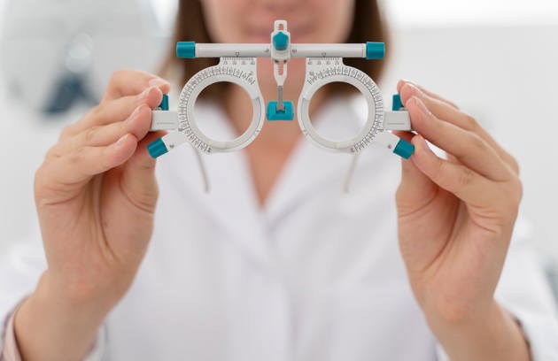 An eye care professional holding a trial frame during a vision assessment at an Eye Hospital in Sharjah.