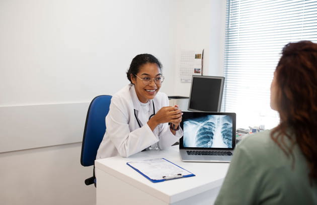 A doctor reviewing a chest X-ray with a patient during a consultation at a Pulmonology Clinic in Sharjah.