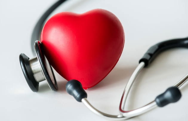 A heart model and stethoscope representing comprehensive cardiac care at a Cardiology Hospital in Sharjah.