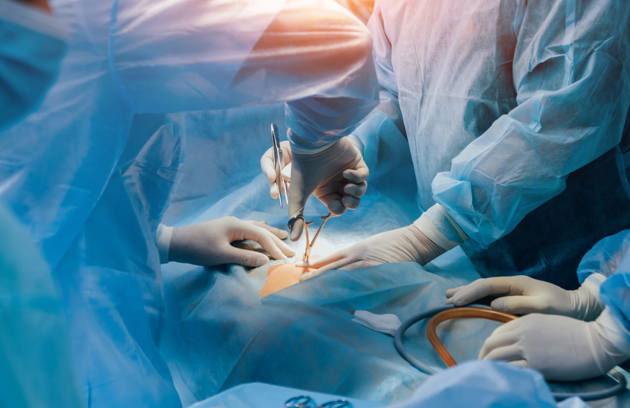 A general surgeon in Sharjah performing a complex surgical procedure in a modern operating room.