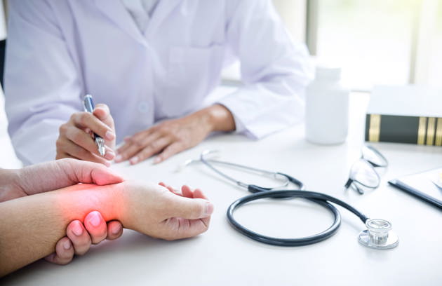 Cropped Image Doctor Examining Patient Hand Having Pain Table Hospital
