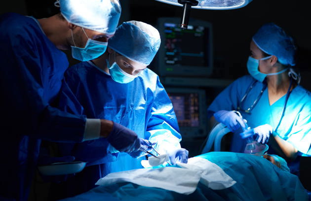 A General Surgery Specialist in Sharjah conducting a surgical operation in a fully equipped operating theatre.