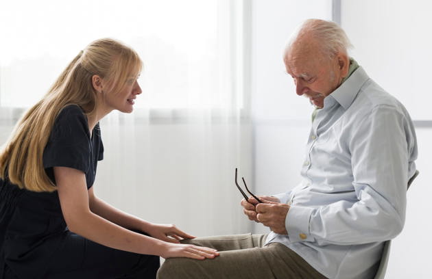 Nurse Having Conversation With Old Man Nursing Home